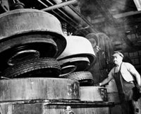Low angle view of a male worker in a tire factory poster print.