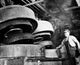 Low angle view of a male worker in a tire factory poster print.
