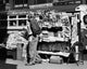Side profile of a vendor in front of a newsstand in New York City poster print.