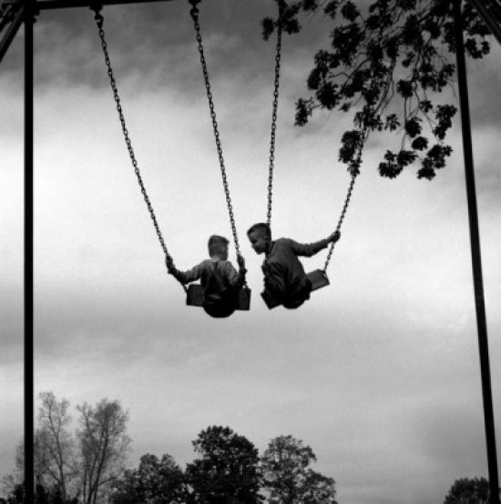 Two Boys on Chain Swing Poster Print showcasing childhood joy.