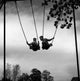 Two Boys on Chain Swing Poster Print showcasing childhood joy.