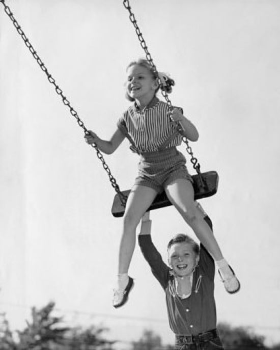 Boy pushing his sister on a swing poster print