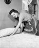 Side profile of a young woman preparing a bed poster print.