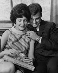 Young woman holding a gift with a young man poster print.