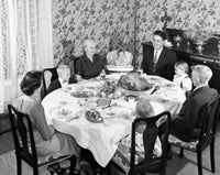 Family gathered around a dining table on Thanksgiving Day poster print.