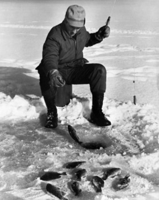 Young Man Ice Fishing on a Frozen Lake Poster Print