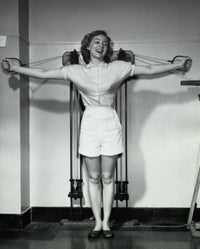 Young woman smiling while exercising in a gym poster print.