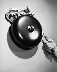 Close-up of a person's hand ringing a bell poster print.