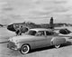 Vintage Car Near an Airplane on a Runway Poster Print