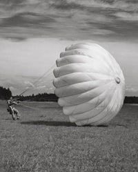 Man with a parachute landing in a field poster print