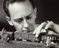 Close-up of a mid adult man holding a model of a toy train.