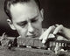 Close-up of a mid adult man holding a model of a toy train.