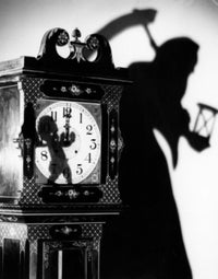 Close-Up of a Clock with Shadow of a Person Carrying a Scythe Poster Print