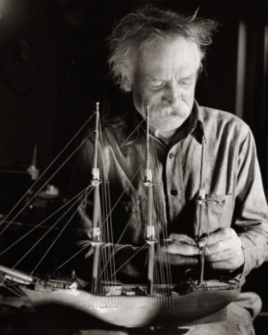 Senior man making a model sailing ship poster print.