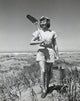 Young woman walking on Long Beach carrying sand pail and shovel poster print.