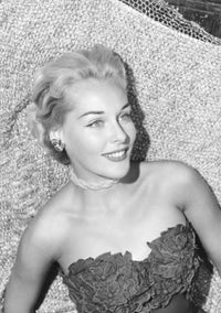 Portrait of a young woman lying on a bed, studio shot poster print.