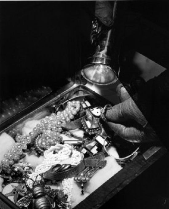Close-Up of Burglar Illuminating Jewelry Poster Print featuring a burglar with a flashlight.