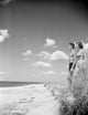 Couple on beach poster print capturing a romantic sunset scene.