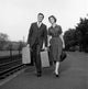 Young couple walking with suitcase at train station poster print