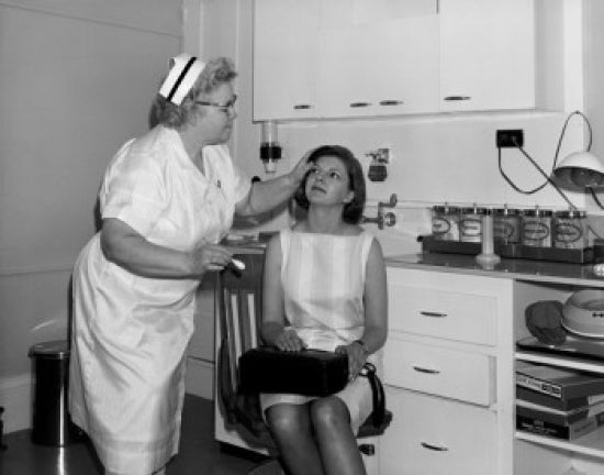 Mid adult woman and female nurse in examination room poster print.