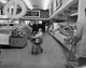 Mother with daughter pulling shopping cart in supermarket poster print