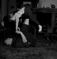 Grandfather playing with granddaughter on carpet poster print