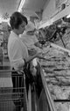 Woman with baby girl shopping in supermarket poster print