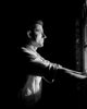 Man Standing and Looking Through Window Poster Print - Side View