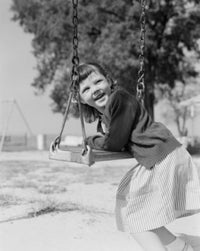 Girl Swinging and Laughing Poster Print capturing joyful childhood moments.