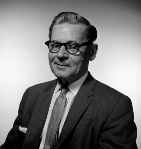 Portrait of a mature businessman wearing glasses in a studio setting.