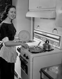 Young woman preparing meal in kitchen poster print