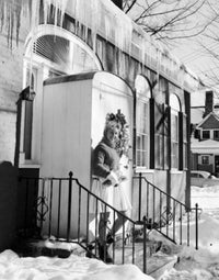 Young woman standing in front of a charming house entrance poster print.