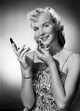 Studio portrait of a young woman applying lipstick, elegant poster print.
