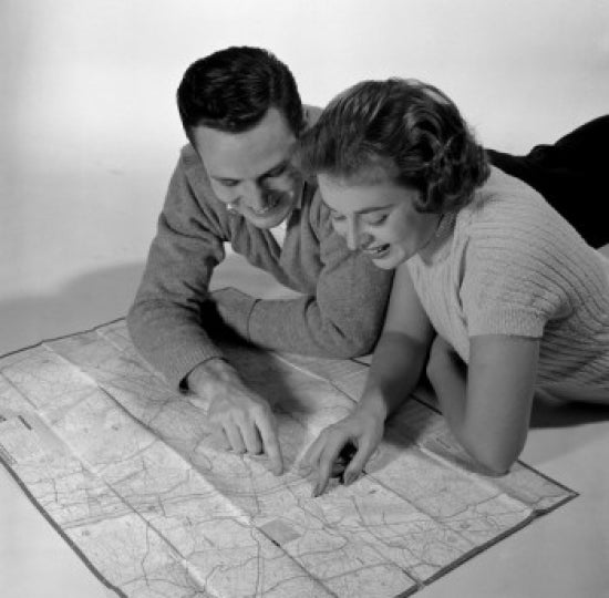 Mid adult couple reading a map poster print, perfect for home decor.
