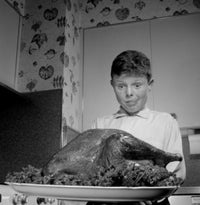 Boy Looking at Roast Turkey Poster Print showcasing a young boy admiring a festive turkey.