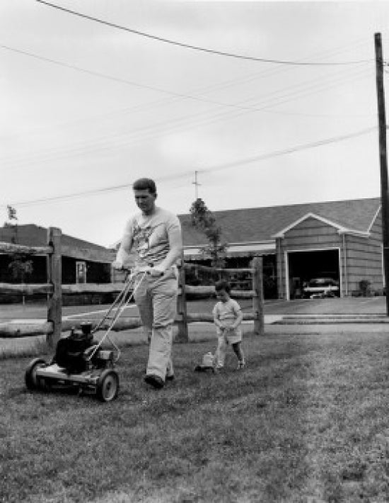 Father mowing lawn with son in backyard poster print