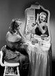 Portrait of a beautiful woman combing hair in front of a mirror poster print.