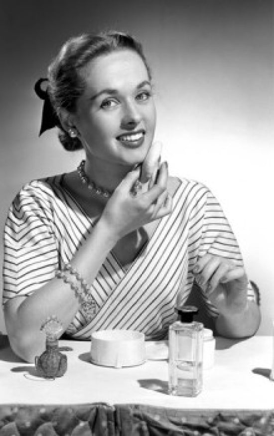 Portrait of a beautiful woman applying make-up poster print.
