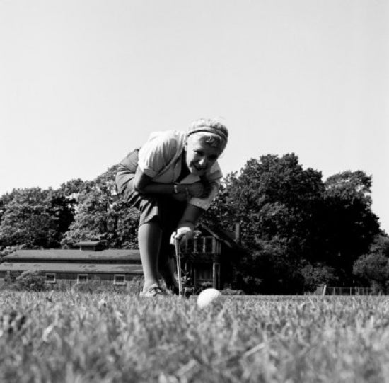 Surface level view of a young woman playing golf poster print.
