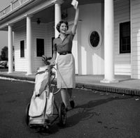 Woman with gold bag waving outside golf country club poster print.