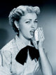 Studio Portrait of Young Woman Sneezing Poster Print showing a young woman in a candid moment.