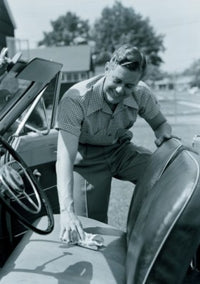 Poster print of a man cleaning the seat of a convertible car.