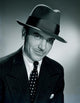 Studio portrait of a businessman wearing a hat, perfect for office decor.