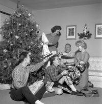 Family opening Christmas gifts around a Christmas tree poster print.