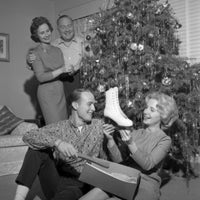 Young woman holding ice skate near Christmas tree poster print.