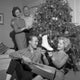 Young woman holding ice skate near Christmas tree poster print.