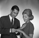 Engagement moment poster print showing a man placing a ring on a woman's palm in a studio shot.