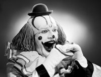 Studio shot of clown eating sandwich poster print