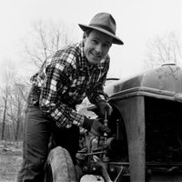 Man Repairing Tractor Poster Print showcasing dedication to agriculture.