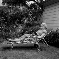 Senior woman lying on chair reading a book poster print